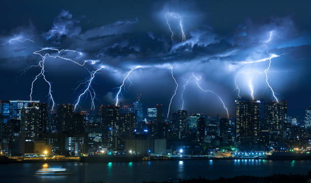 Lightning storm over city in blue light stock photo