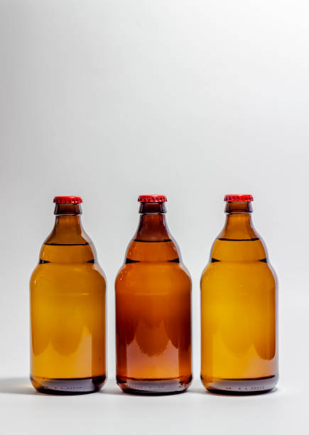istock Beer bottles with a red cork on a gray background. Design. Minimalism. Creative idea. Mock-up. 1156955316