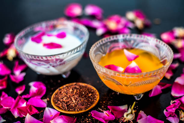 istock Milk face pack for clear complexion on shiny black wooden surface i.e. Raw milk well mixed with sandalwood powder in a glass bowl and entire raw ingredients on the surface. 1156955527