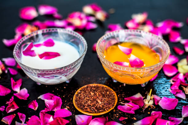 istock Milk face pack for clear complexion on shiny black wooden surface i.e. Raw milk well mixed with sandalwood powder in a glass bowl and entire raw ingredients on the surface. 1156955530