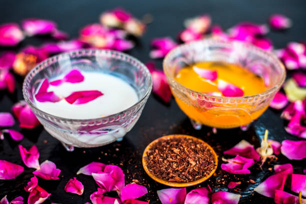 istock Milk face pack for clear complexion on shiny black wooden surface i.e. Raw milk well mixed with sandalwood powder in a glass bowl and entire raw ingredients on the surface. 1156955532