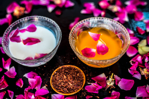 istock Milk face pack for clear complexion on shiny black wooden surface i.e. Raw milk well mixed with sandalwood powder in a glass bowl and entire raw ingredients on the surface. 1156955538