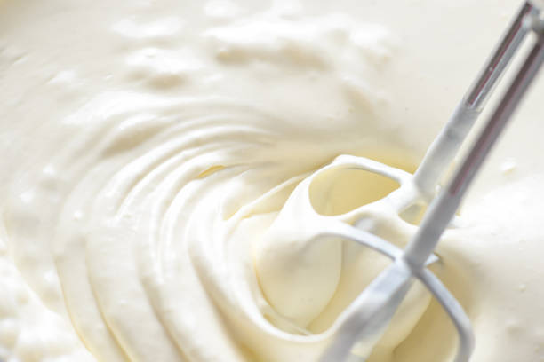 istock Whipping cream with a mixer. Bubbles on cream 1156955542