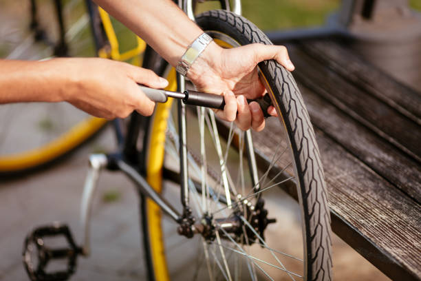 Inflate A Bike Tire Close-up of a man pumping bicycle wheel on the street. inflating photos stock pictures, royalty-free photos & images