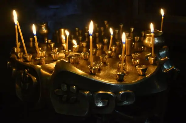 Candles on a golden candleholder in Catholic church