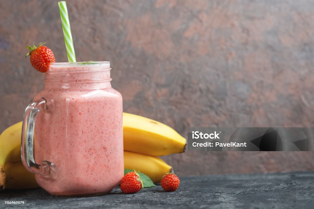 Strawberry smoothie with banana or strawberry milkshake in a glass jar with copyspace Strawberry Smoothie Stock Photo