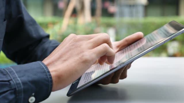 Man Reading text on Digital tablet