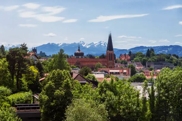 City Bregenz with church and Alps on background in sunny spring day, Austria.