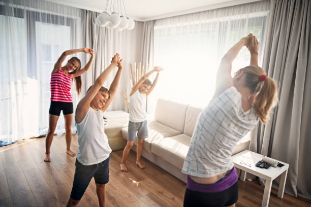 madre con niños estirando en casa - common women teenage girls exercising fotografías e imágenes de stock