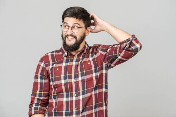 Portrait of focused smart male model with with thoughtful determined expression, thinking. Isolated over grey