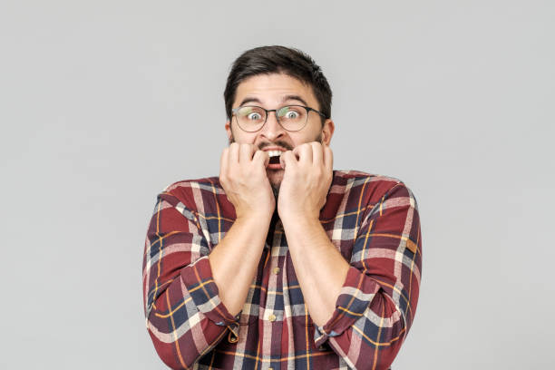 istock Scared emotional surprised male model notices his phobia aside, exclaims in terror, keeps hands on cheeks, isolated over gray background 1156973780