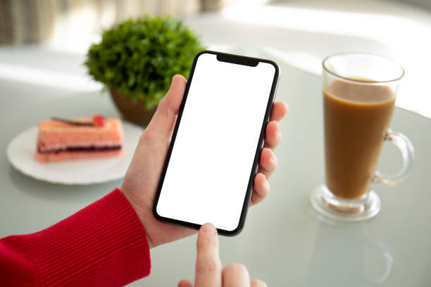 istock female hands holding phone with isolated screen in a cafe 1156976973
