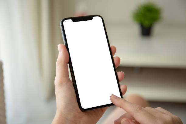 istock female hands holding phone with isolated screen in room 1156977098