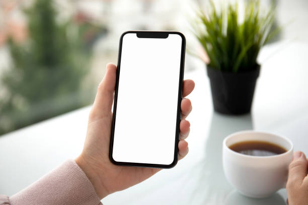 istock female hands holding phone with isolated screen in summer cafe 1156978157