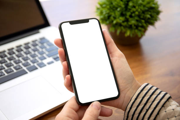 istock female hands holding phone with isolated screen in the office 1156978998