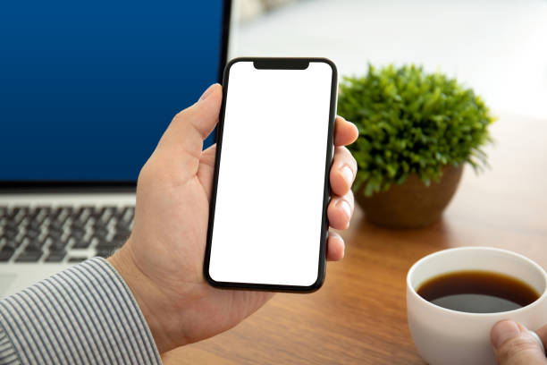 istock male hands holding phone with isolated screen in the office 1156981328