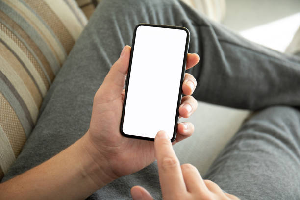 istock male hands holding phone with isolated screen on the sofa 1156981873