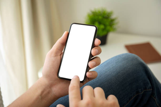 istock man hands holding phone with isolated screen in the room 1156981967