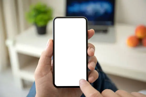 Photo of man hands holding phone with isolated screen in the room