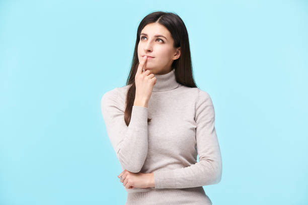istock young caucasian woman looking up thinking 1156987123