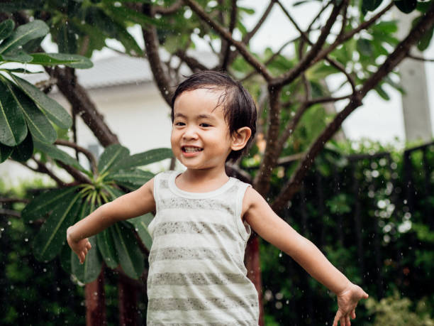 istock Happy little boy playing with garden sprinkler 1156989747