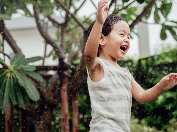 istock Happy little boy playing with garden sprinkler 1156989851