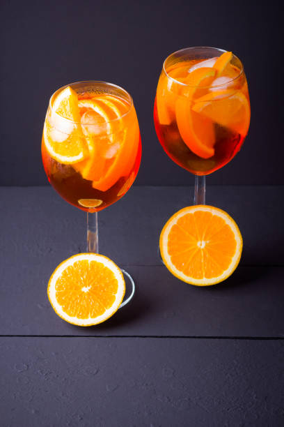 istock Cocktail Spritz on black background. Summer alcohol cocktail with orange fruit and fresh mint. Italian cocktail Spritz on wooden boards 1156990076