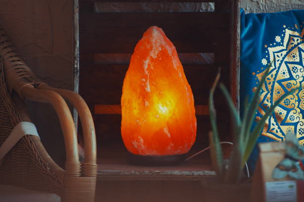 istock Himalayan salt lamp on wooden table illuminated 1156990667