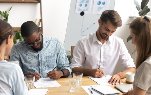istock Happy smiling diverse businessmen putting signature on paper document 1156995084
