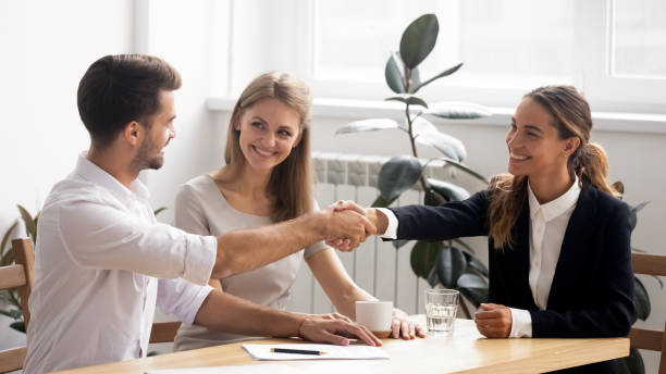 Excited smiling caucasian business people handshaking greet each other Excited smiling caucasian business people handshaking greet each other at formal meeting. Satisfied male and female partners shake hands after successful negotiation or hiring and signing contract narrow stock pictures, royalty-free photos & images