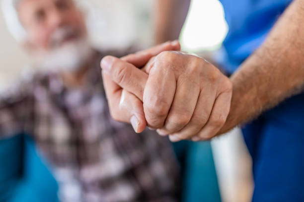 istock Doctor Holding Elderly Man Hand With Care 1156995504