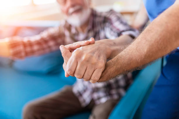 istock Doctor Holding Elderly Man Hand With Care 1156995517