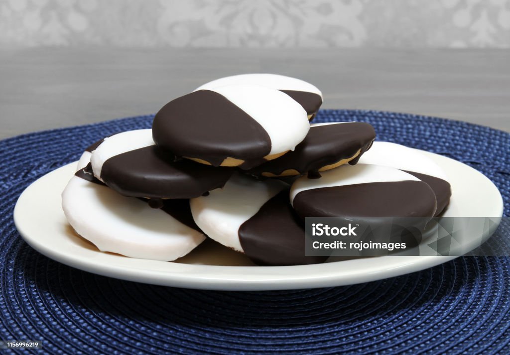 Black and White cookies on an oval plate. Black and white cookies stacked on an oval plate.  Macro, close up with copy space. Cookie Stock Photo