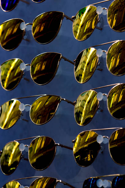 istock Close up image of multiple cool yellow sunglasses on a blue background 1156997101