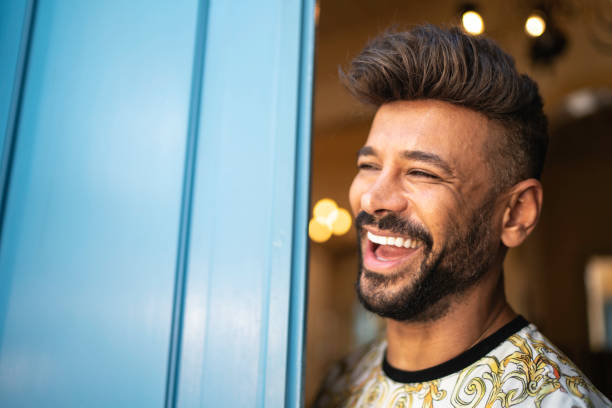 istock Happy latin man standing by a blue door 1156997876