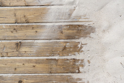 Weathered Wooden Boardwalk on Sand / Aged beach brown wooden floor over summer sand