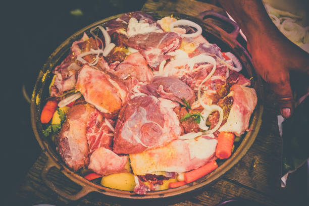 istock Fresh meat with vegetables prepared for baking, on a wooden table 1156998019