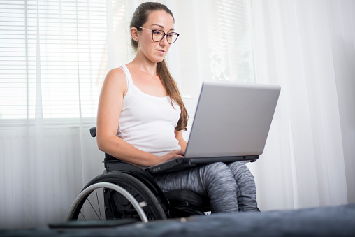 Young woman with disabilities works from home, over the Internet.