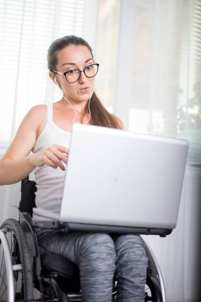 istock Young woman with disabilities works from home, over the Internet. 1156998540