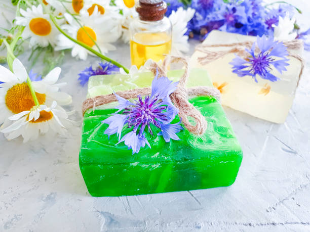 istock oil, chamomile flower soap, cornflower on a gray concrete background 1156999424