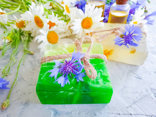 istock oil, chamomile flower soap, cornflower on a gray concrete background 1157000528