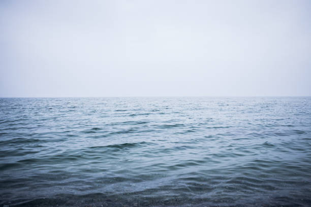 istock Clean and calm blue sea or ocean. Mist above the water surface 1157001727
