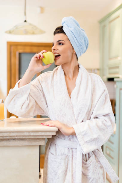 istock Morning snack, young woman having fruit for breakfast 1157001996
