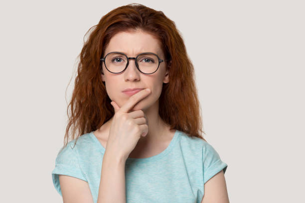 istock Pensive redhead girl in glasses thinking over idea 1157002213