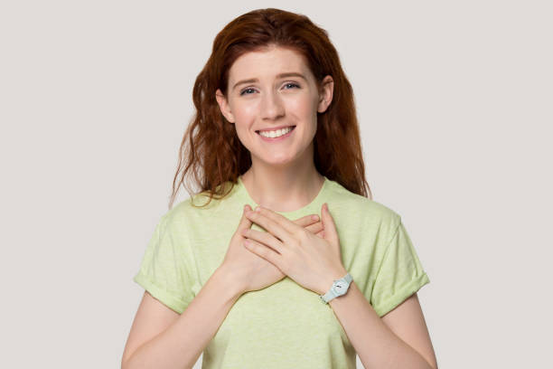 istock Grateful red-haired girl with hands on chest feel thankful 1157002232