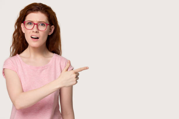 istock Surprised red-haired girl point blank copy space 1157002249