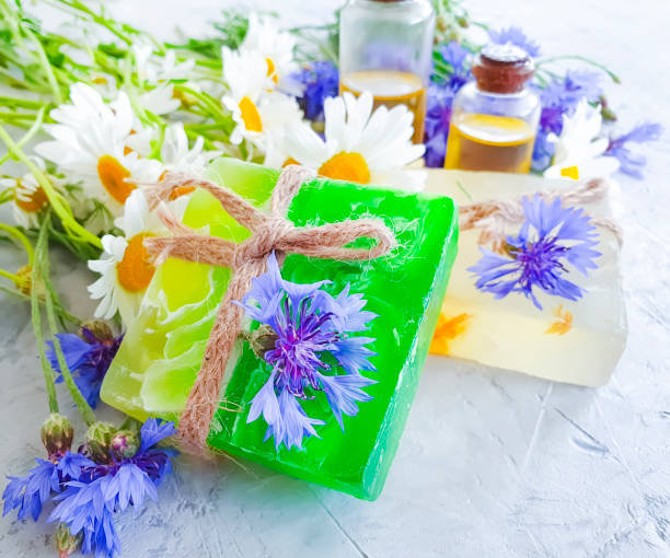 istock oil, chamomile flower soap, cornflower on a gray concrete background 1157002398