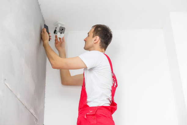 istock Male Technician Standing On Stepladder Fitting Cctv Camera 1157003424