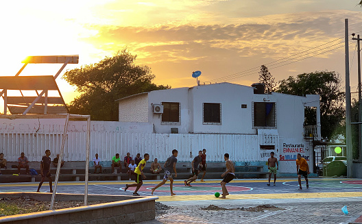 Riohacha, Colombia - March 25, 2019: People playing football at sunset in Riohacha, the capital of La Guajira Department on the Caribbean sea, in northern Colombia.