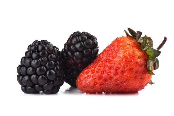 istock Two ripe blackberries and one strawberry over white background. Macro shot. 1157007624